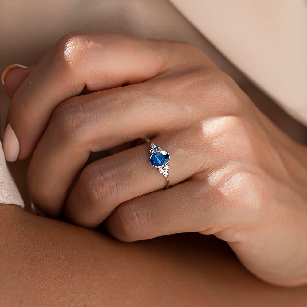 kadın modelin parmağında pırlantalı safir taşlı tektaş yüzük