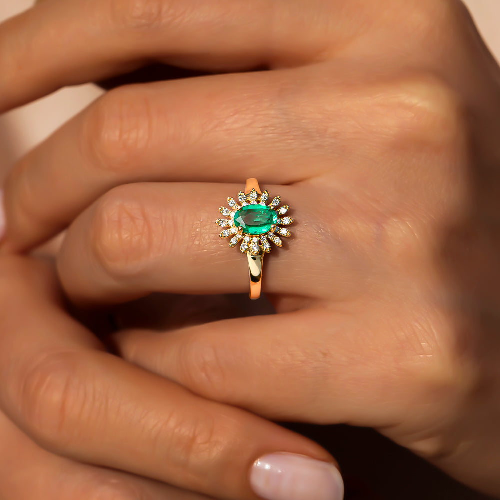 kadın modelin parmağında ortada oval kesim zümrüt taşı ve kenarlarında 30 adet pıranta taşı bulunan vintage tasarım palmiye yüzük