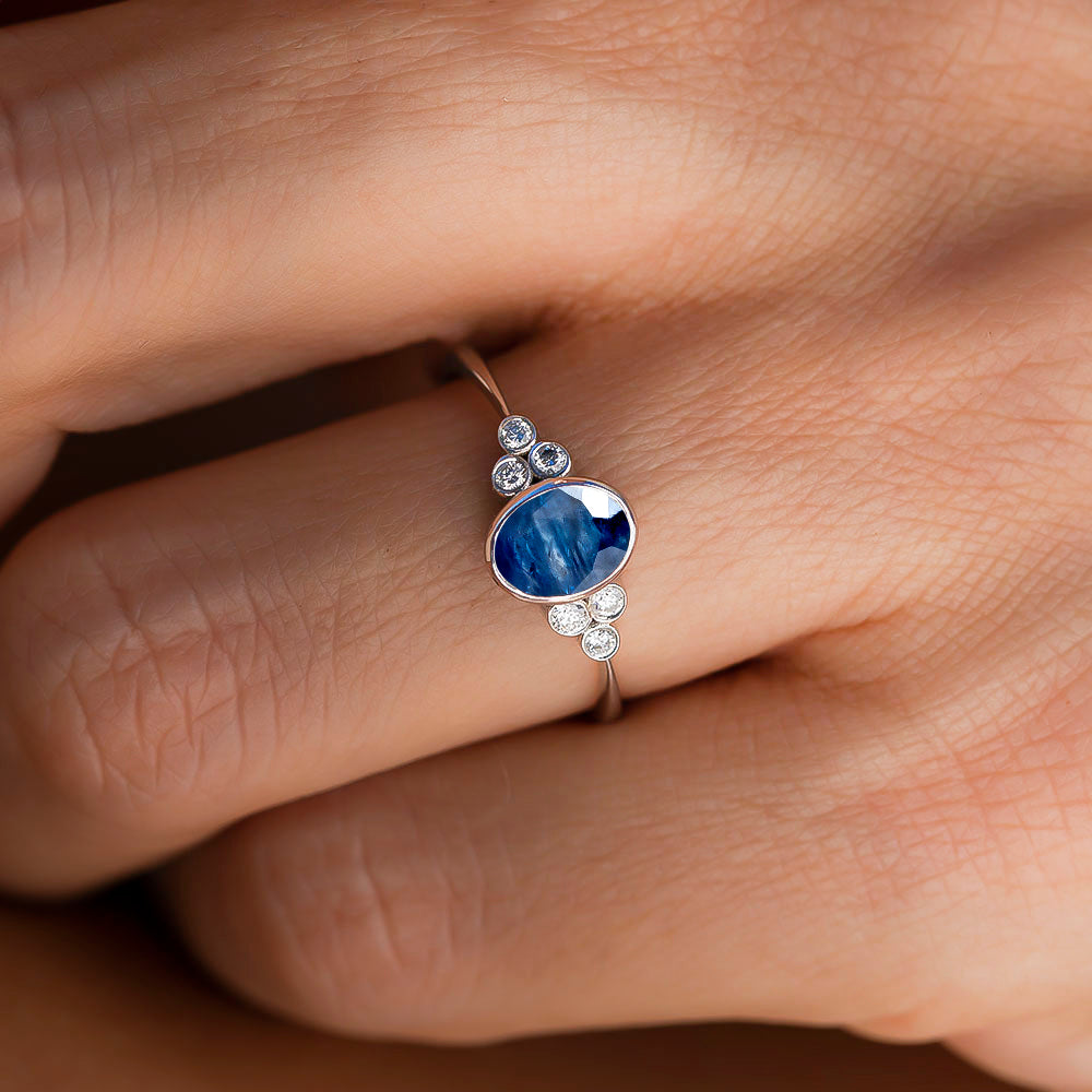 kadın modelin parmağında pırlantalı safir taşlı tektaş yüzük