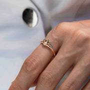 Taç tasarımlı pırlantalı ve zümrüt taşlarından oluşan vintage yüzüğün kadın modelin parmağında görüntüsü
