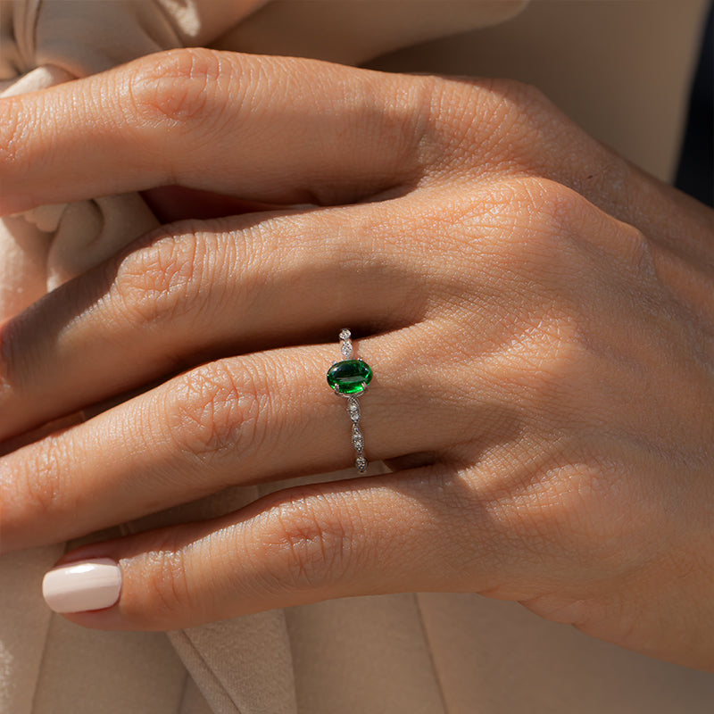 kadın modelin parmağında ışıldayan Pırlantalı kapşon kesim zümrüt taşlı vintage tasarım yüzük