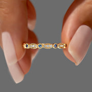 safir ve pırlanta taşlarından oluşan vintage tarzında bir yüzüğü parmakları arasında tutan bir kadının parmaklarının yakın plan görünümü
