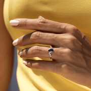 kenarlarında pırlanta taşları ve ortasında oval kesim mavi safir taşı bulunan vintage tarzı yüzüğün kadın modelin parmağındaki görüntüsü