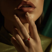 Kenarlarında pırlanta taşları ve ortasında oval kesim yakut taşı bulunan vintage tasarım yüzüğün bir kadın modelin parmağındaki görüntüsü