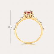 vintage tarzında ortasında turmalin taşı ve kenarlarında pırlantalar bulunan altın rengi yüzüğün üst kısmının görüntüsü