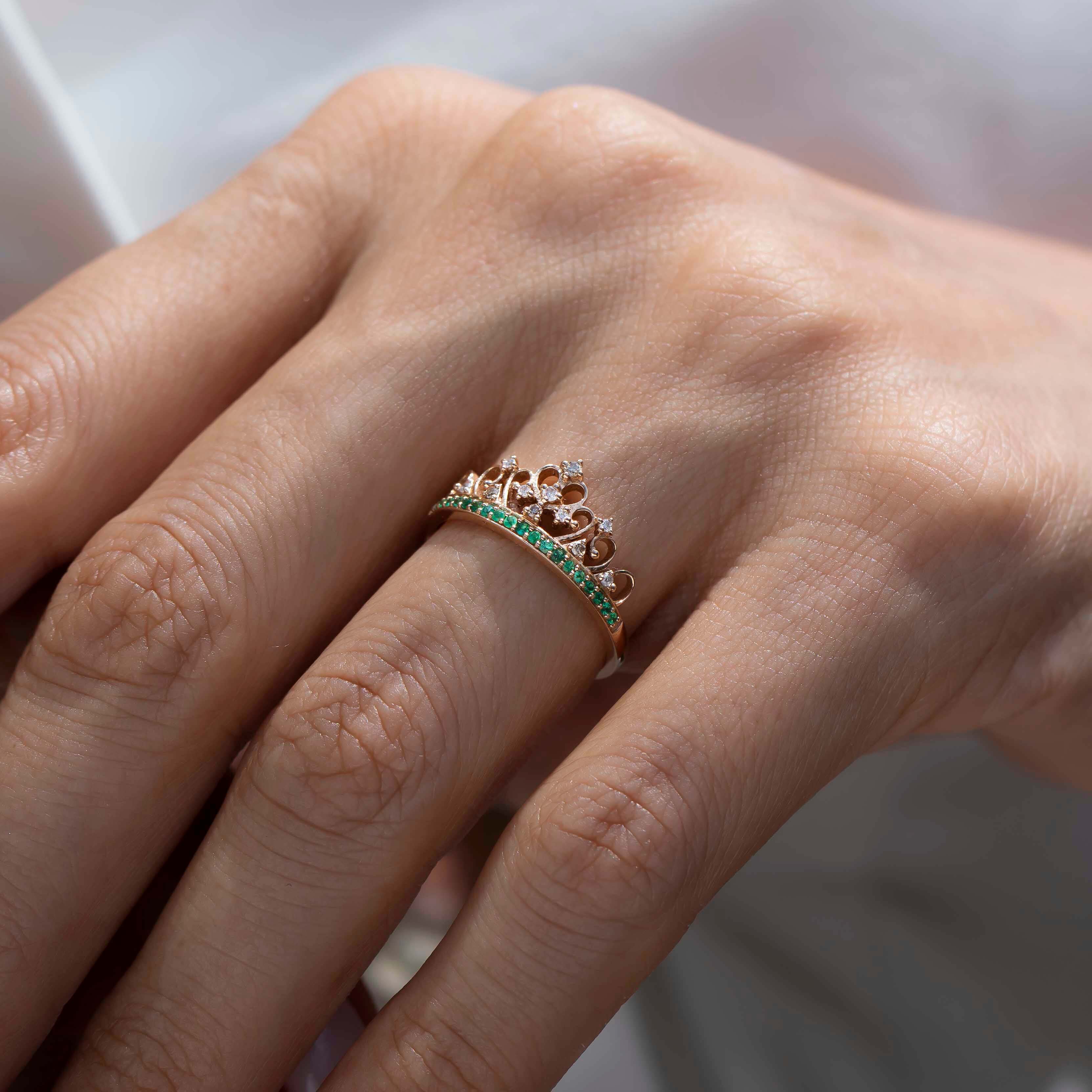 asimetrik dizilmiş pırlantalar ve sıralı dizilmiş zümrüt taşlarıyla tasarlanmış özel vintage tasarım taç yüzüğün kadın modelin parmağındaki görüntüsü